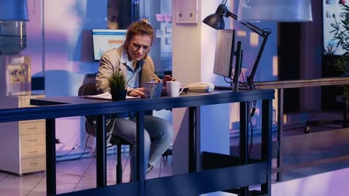 Woman Working Late in a Modern Office