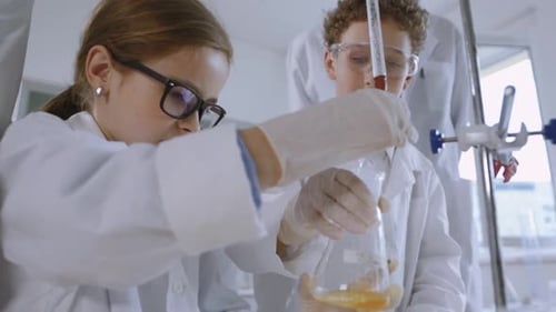 Children Performing Science Experiment with Teacher in Lab
