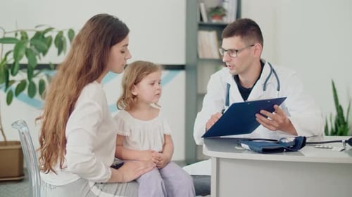 Doctor Consults with Child and Adult Woman in Office