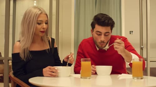 Young Couple Eating Cereal Together Indoors