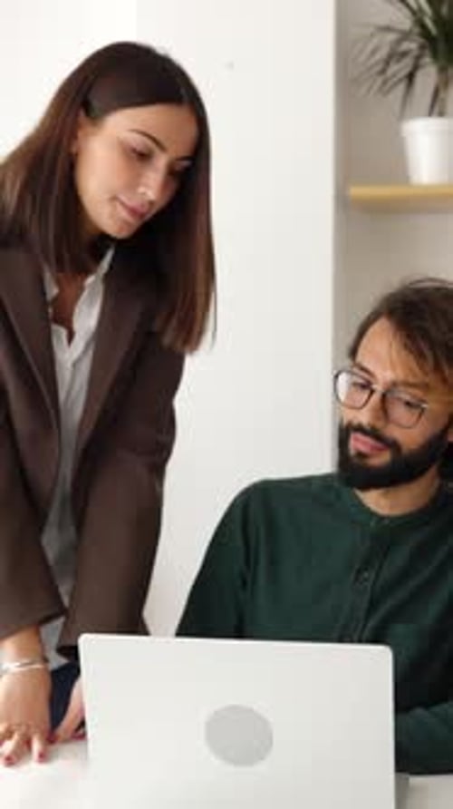 Coworkers Collaborating on Laptop in Bright Office