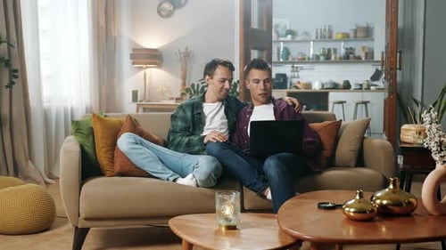 Young Men Relaxing with Laptop at Home