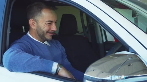 Smiling Man Holds Up Car Keys Inside White Car