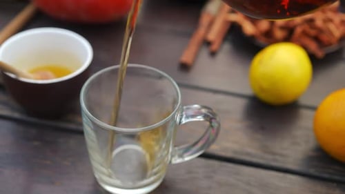 High Angle View Pouring Green Tea From Teapot in Cup Outdoors