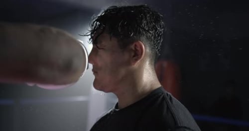 Man getting punched in the face in super Dramatic slow-motion at 800 fps impact with droplets of