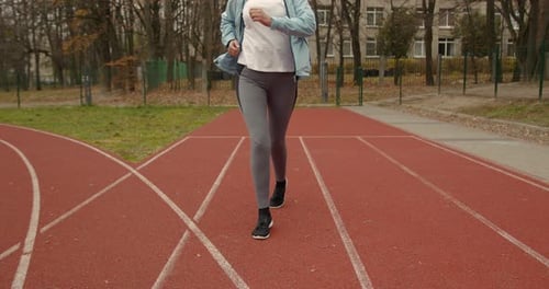 Old Fit Woman Running Marathon at Stadium Arena