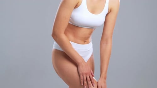 Young Fit and Beautiful Woman in White Swimsuit Posing Over Grey Background Healthcare Diet Sport