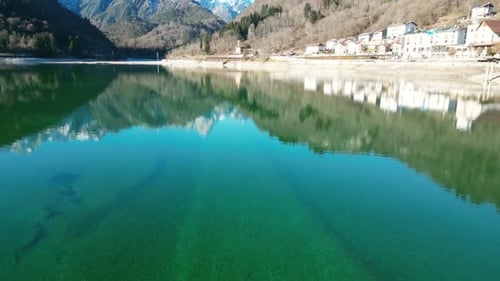 Vue aérienne par drone du lac Barcis — Lumière hivernale ensoleillée et sommets enneigés au loin