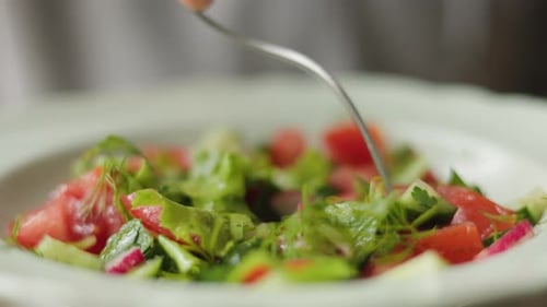 Eating Fresh Vegetable Salad with Silver Fork