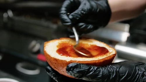 Chef Spreads Sauce on Hamburger Bun