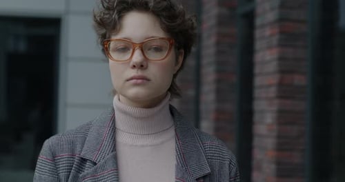 Young Woman Portrait With Curly Hair and Glasses
