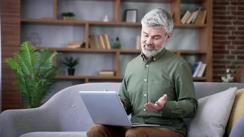 Man Talking on Laptop Video Call at Home