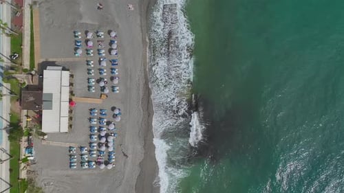 Aerial View A Charming Coastal Cafe and Azure Beach Invite Visitors to Relax on Sun Loungers with