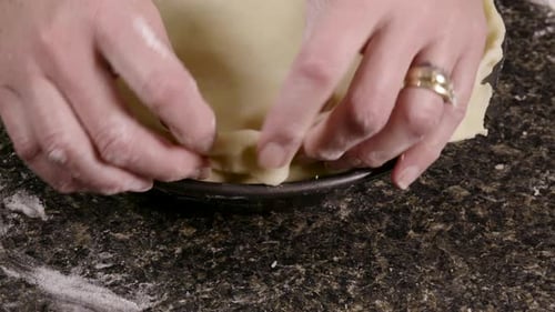 Hands Shaping Pie Crust in Pie Pan
