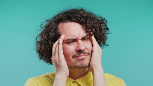Young Man Having Hypertension Headache Blue Studio Guy Putting Hands on Head
