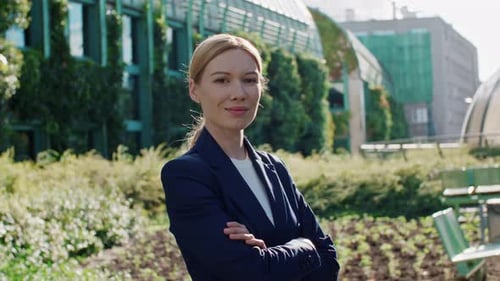 Smiling Businesswoman Stands Confidently in Urban Green Space