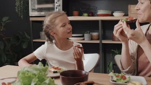 Mother and Daughter Enjoying Sandwiches Together