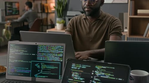 Black IT Specialist Coding and Adjusting Glasses while Working at Office Table
