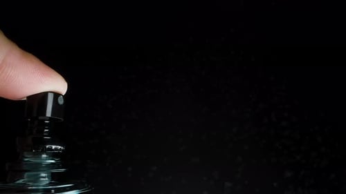 Spraying bottle up close on black background