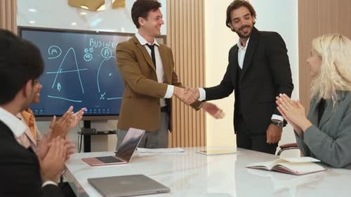 Business Team Celebrates Success with Handshake and Applause