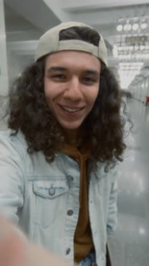 Smiling Man Vlogging With Skateboard in Urban Building