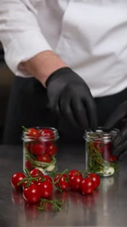 The chef preserves vegetables in the kitchen. Close-up