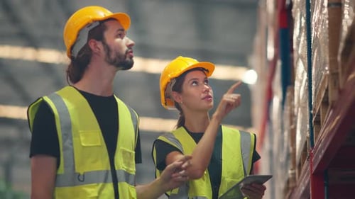 Man and woman workers checks products stock inventory with digital tablet in the retail warehouse