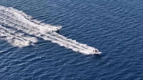 Motorboat and Jet Skis Speeding on the Ocean