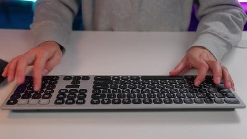 Hands Typing on Silver Computer Keyboard at Desk