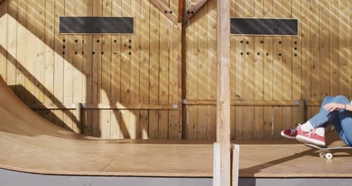 Video of happy diverse female and male skateboarders having fun in skate park