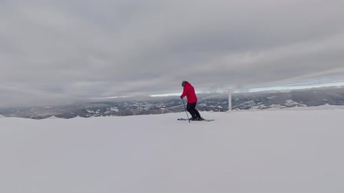 Skier in a Pink Jacket Riding on a Wide Snowy Mountain Slope in Winter Scenic Landscape with