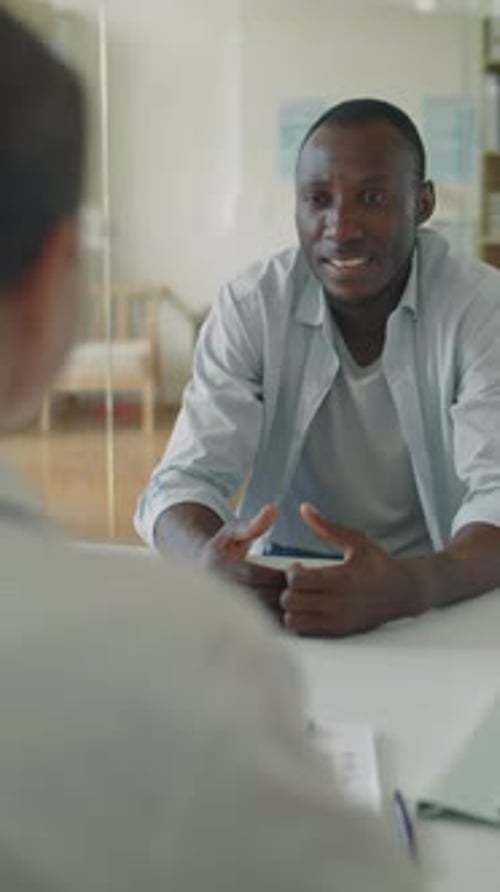 Man Talking and Gesturing at Meeting Table