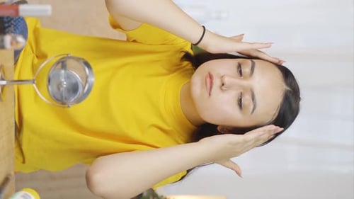 Vertikales Video von Die junge Frau betrachtet ihre Haut. Sie untersucht sich selbst im Spiegel.