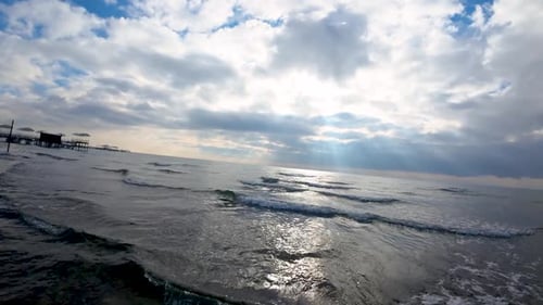 Ocean with huge cloud and pier during winter