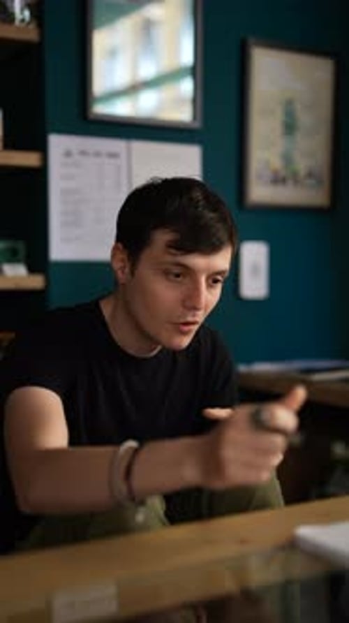 Un jeune homme est absorbé dans une discussion en train de prendre des notes à un bureau dans un bureau moderne