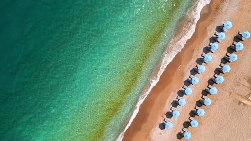 Topdown View of Sandy Beach with Sun Umbrellas and Turquoise Sea Water
