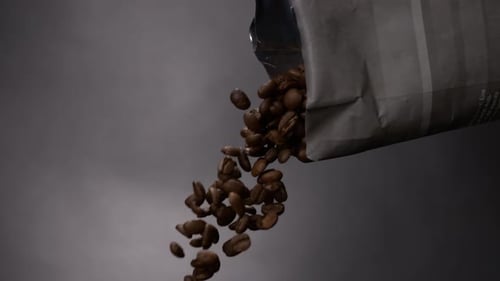 Coffee bean falling out of a bag in a coffee in super slow motion