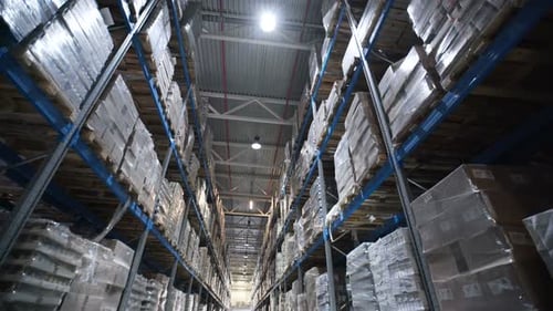 Inside a large warehouse terminal rows of cardboard boxes stretch into the distance