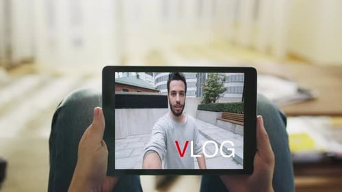 Gelegenheitsmann, der auf seiner Couch liegt und modische Video-Blogs auf seinem Tablet-Computer ansieht. Inschrift