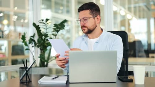 Focused Businessman Working on Documents in Modern Office