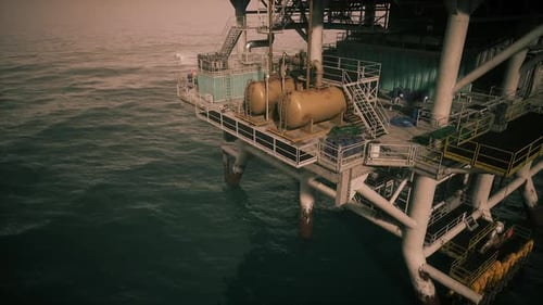 Oil Rig Structure Over Ocean Waters at Sunset with Operational Equipment
