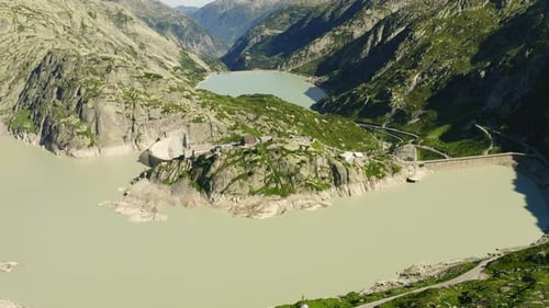 Forward climb and pan down over Grimsel hospice in the Swiss alps with nice view of the grimsel dam.