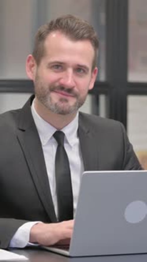Businessman Working on Laptop Gives Thumbs Up