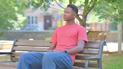 Young Man Relaxing on Park Bench