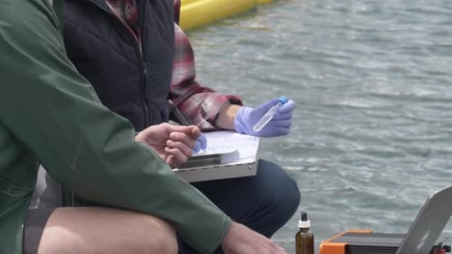 Scientists Analyzing Water Sample from Lakeside