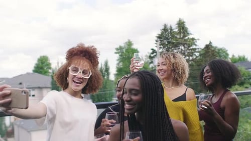 Smiling women enjoy celebration on suburban rooftop