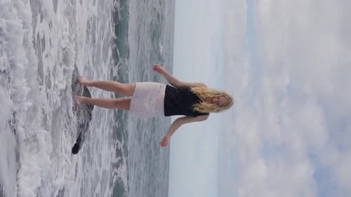 Adult Girl Stands on a Rock a Sandy Beach Next to the Ocean the Sky Above Her