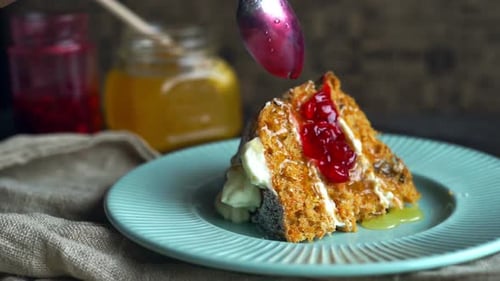 Le chef verse de la confiture de baies sur un délicieux morceau de gâteau, une garniture de dessert sucrée.