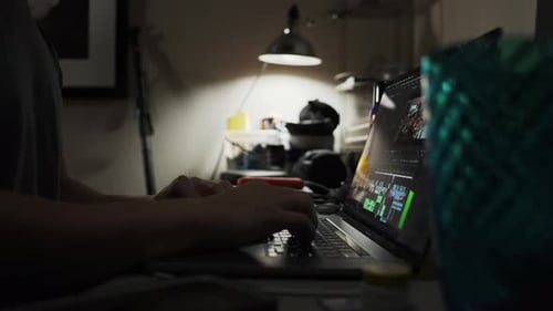 Person editing videos, and working hard in dim lighting