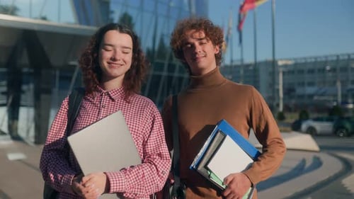 Two Relaxed Students Standing in Front of Modern Glasswalled University
